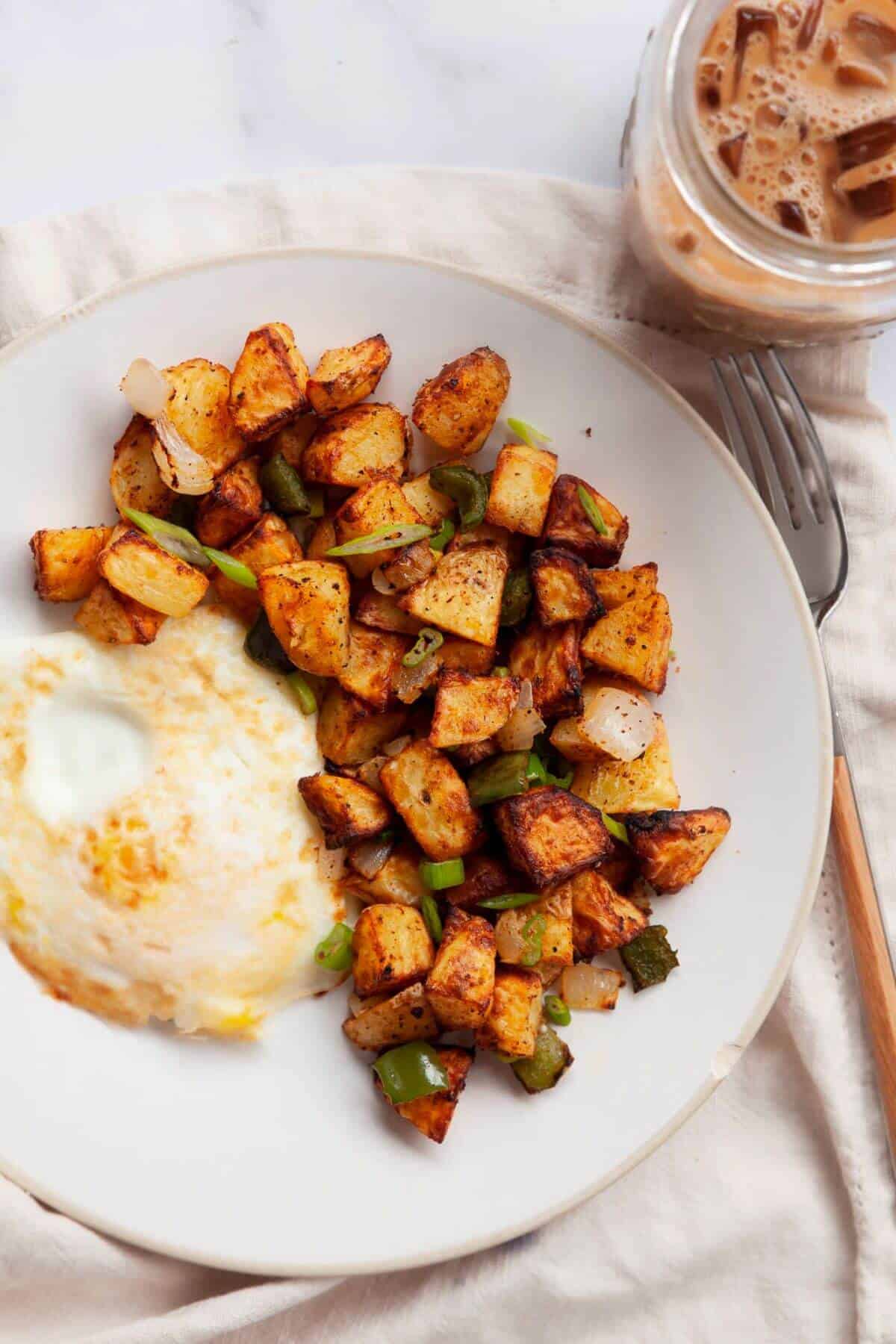 Crispy air fryer home fries served with an egg.