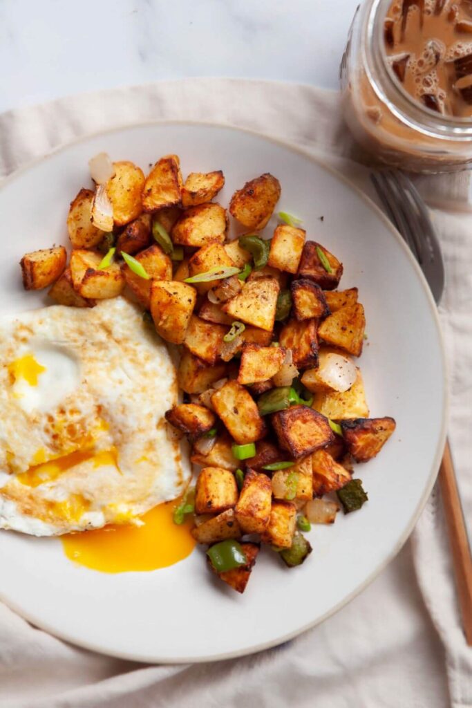 air fryer breakfast potatoes with an egg on a plate