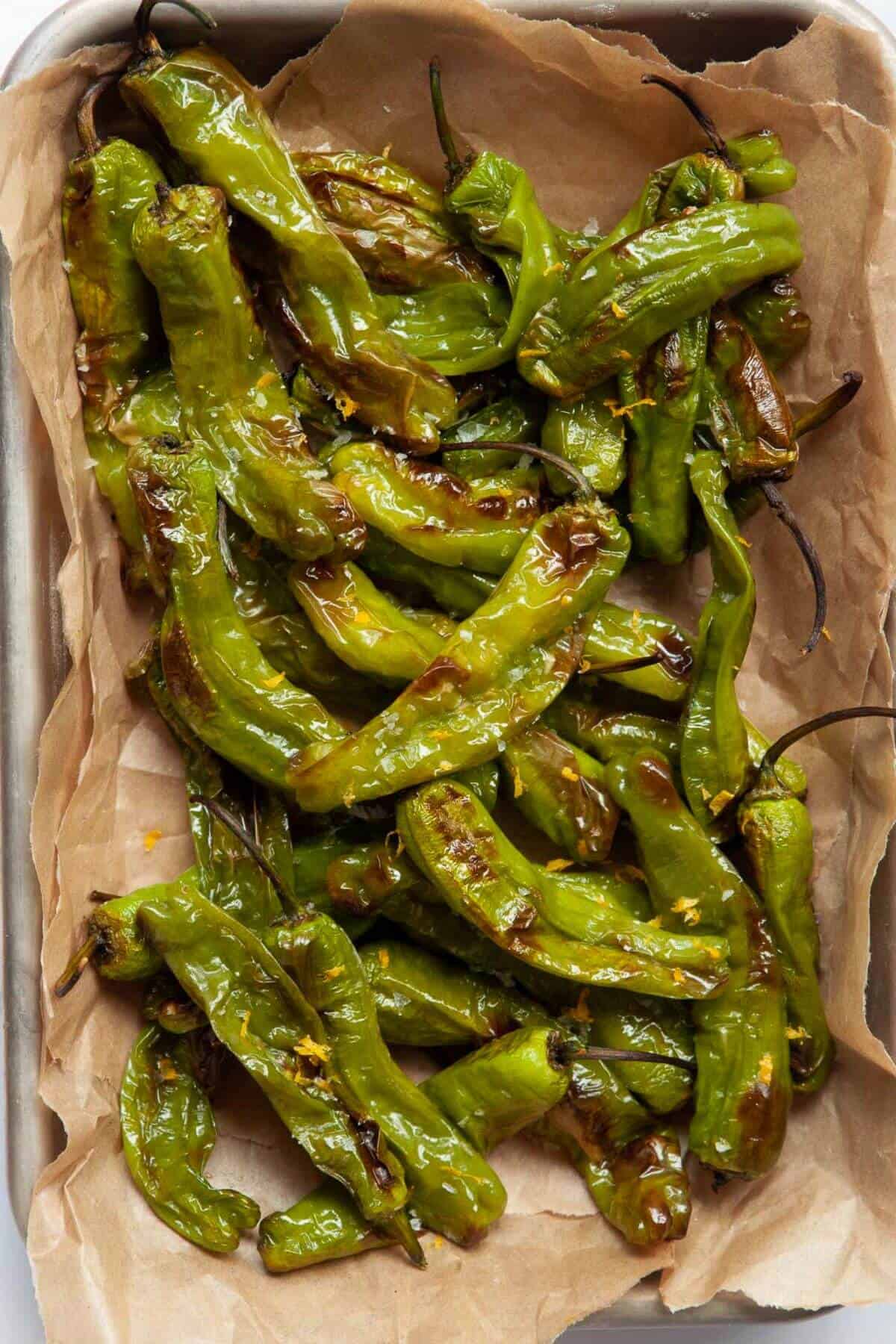 Blistered air fryer shishito peppers with lemon zest and sea salt.