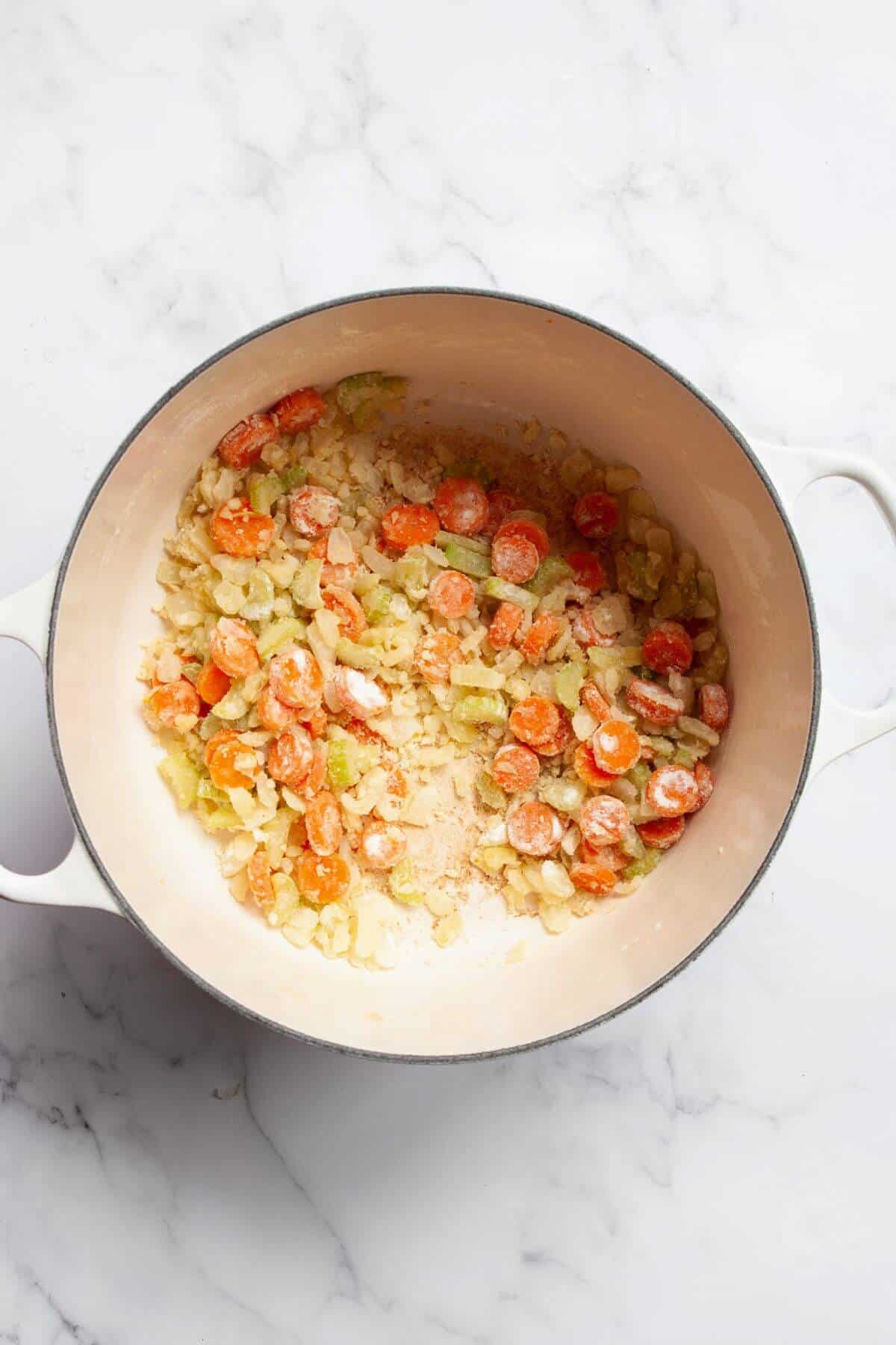 Flour stirred into cooked carrots, celery, and onion to make a roux to thicken the soup.