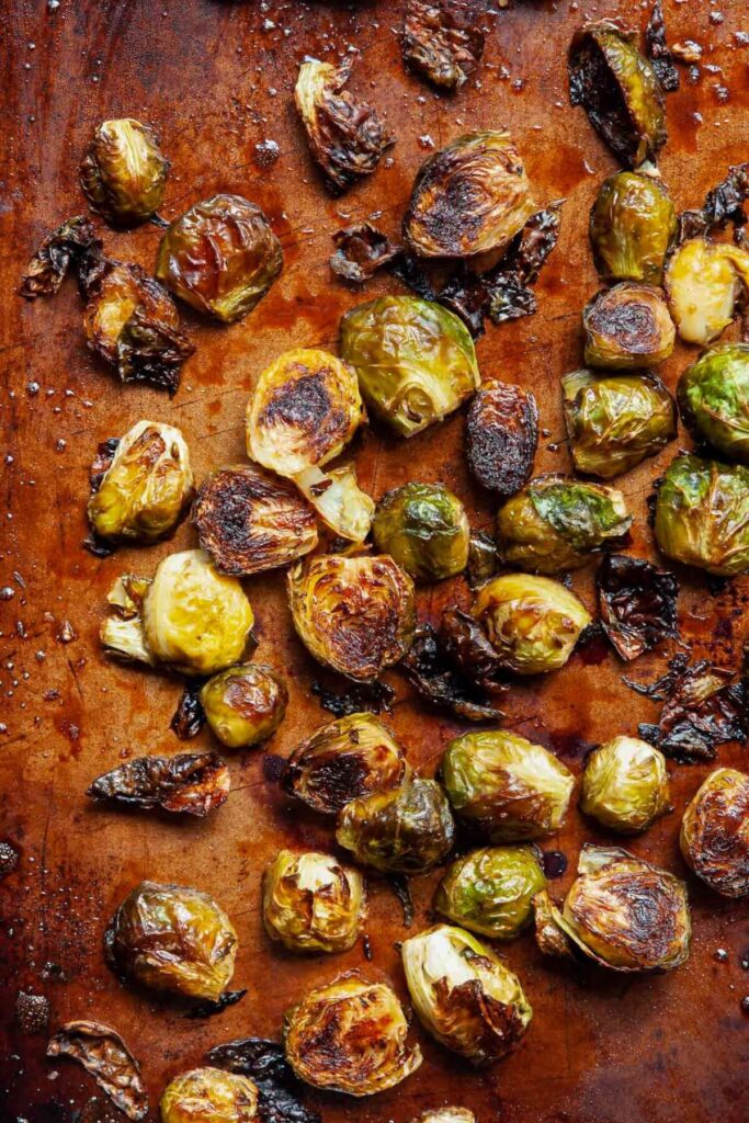 crispy balsamic maple glazed brussels sprouts on a baking sheet after roasting in the oven