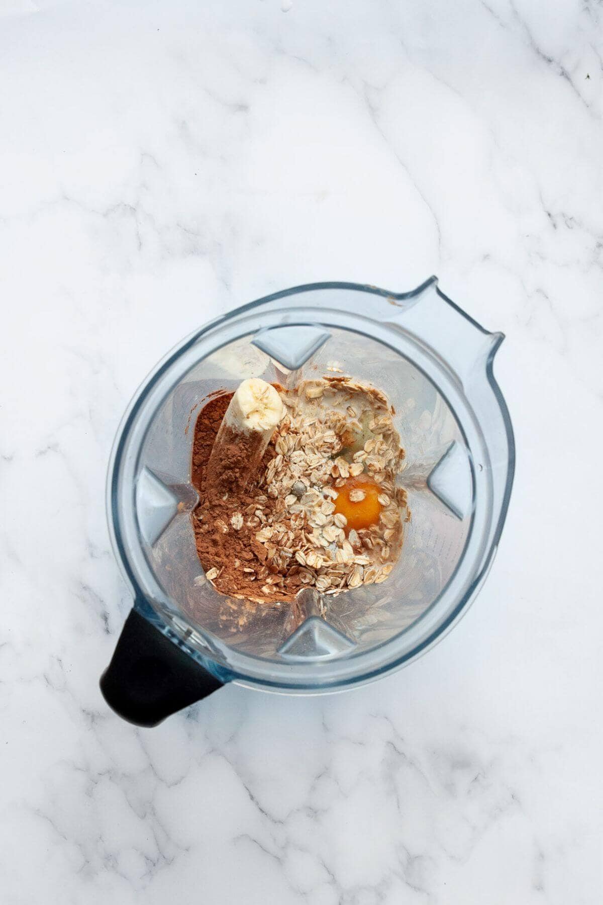 All ingredients in chocolate baked oats in a blender before blending.
