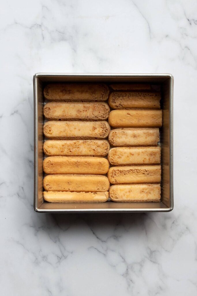 layering gluten-free lady fingers dipped in espresso at the bottom of an 8x8-inch pan