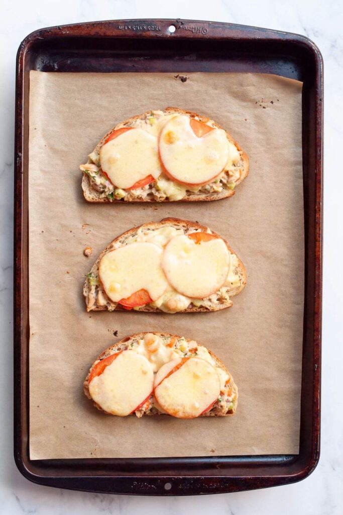 open-face tuna melts on a baking sheet after melting the cheese