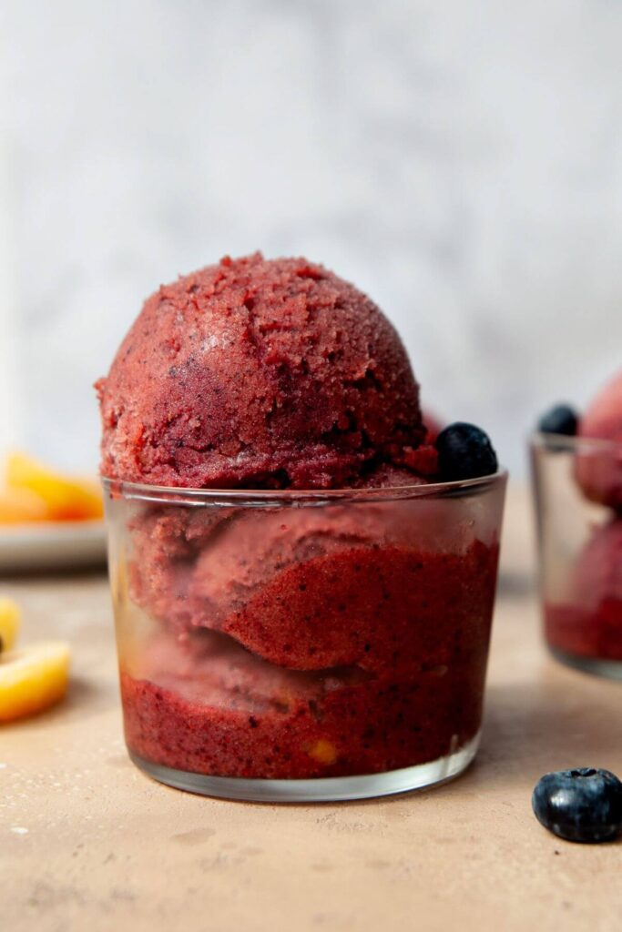 two scoops of blueberry peach sorbet in a serving cup