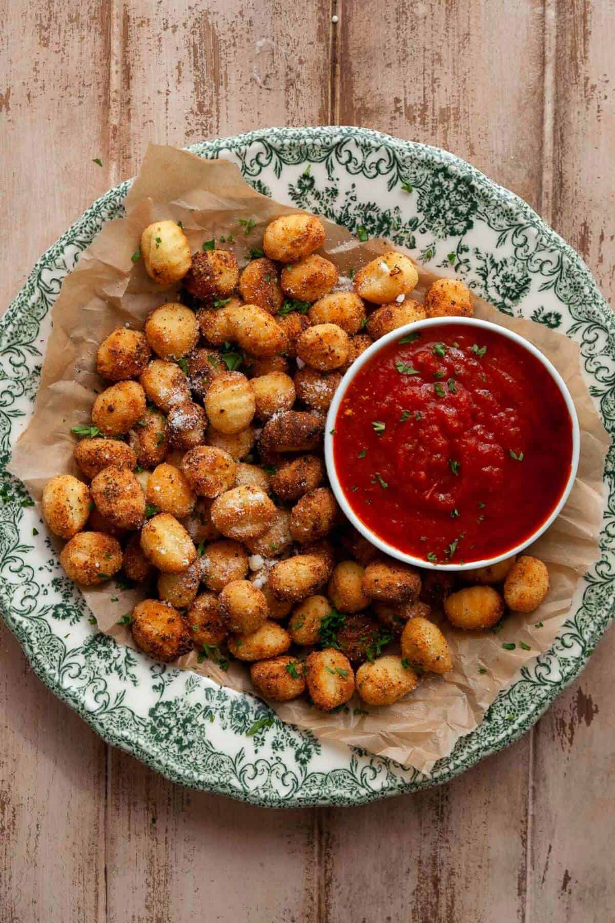 Air fryer gnocchi on a plate with marinara sauce for dipping.