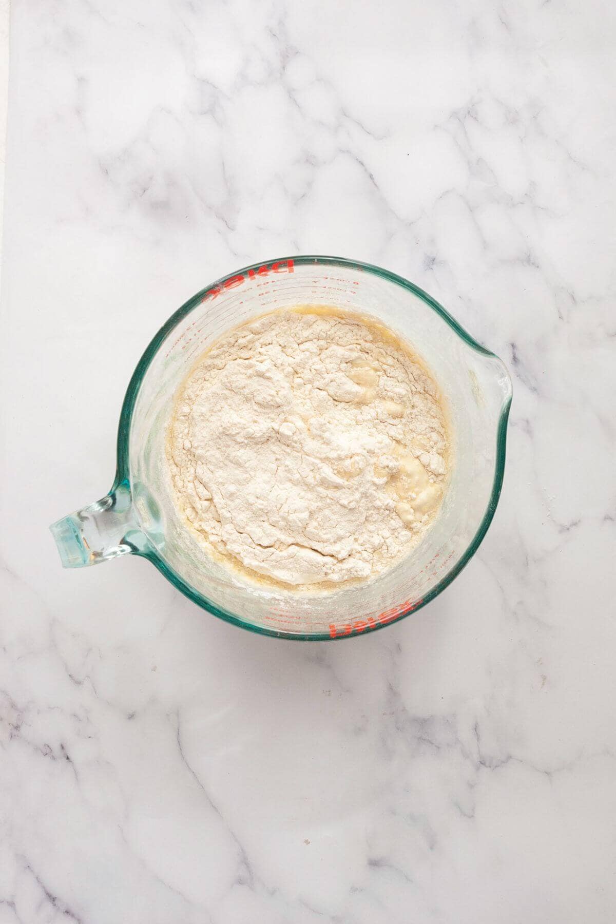 Adding flour, salt, and baking powder to wet ingredients.