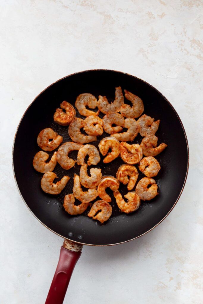 cooking shrimp in a pan with olive oil