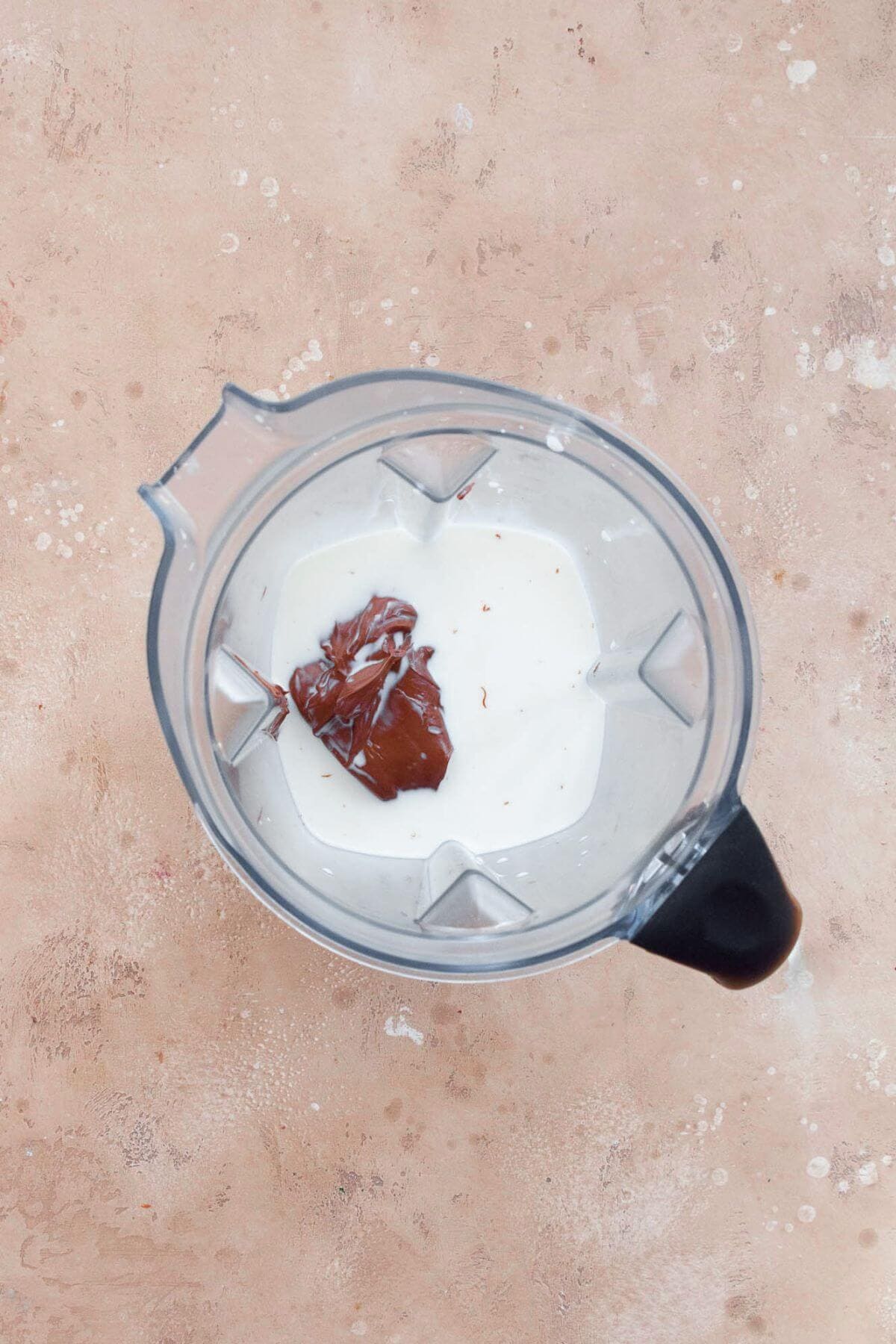Nutella and milk in a blender before blending into chocolate Nutella milk.