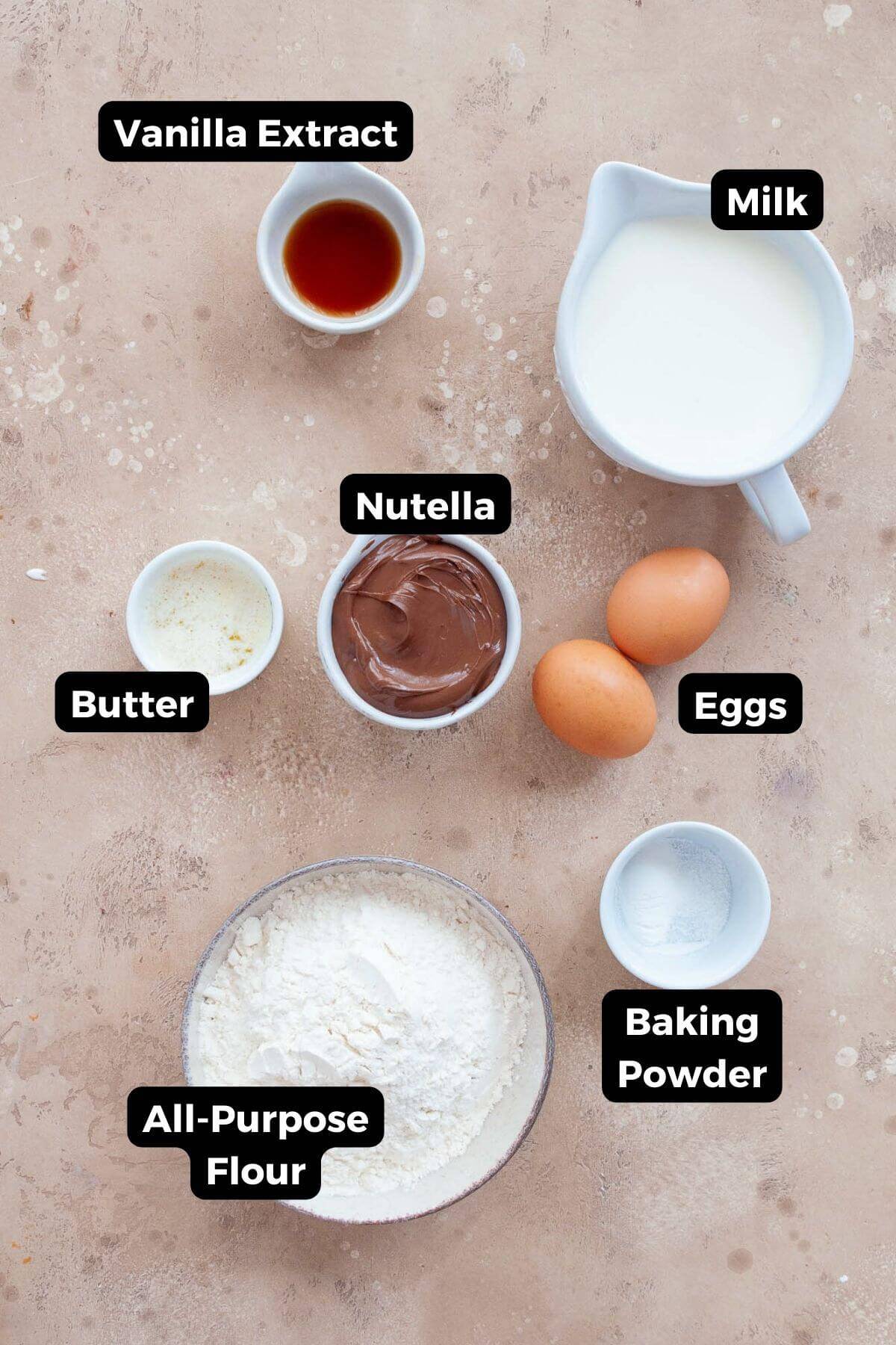 Ingredients for Nutella waffles including Nutella, milk, eggs, flour, butter, baking powder, vanilla, and salt.