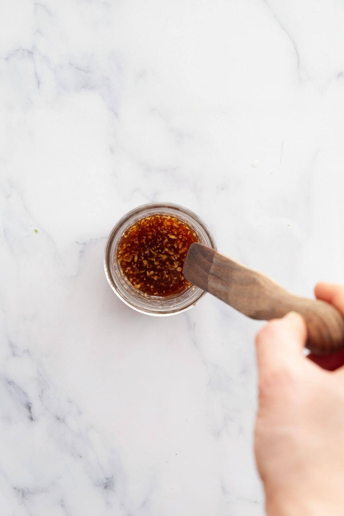 Oil-free Thai mango salad dressing made with lime juice, soy sauce, and ginger in a small bowl.