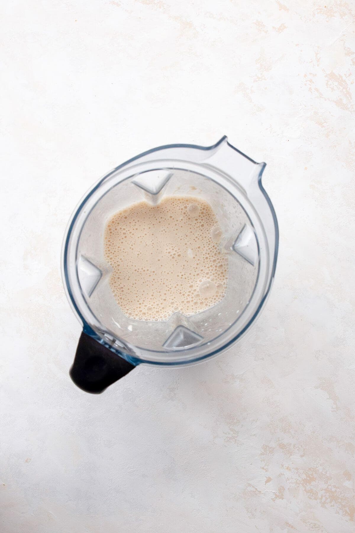 Smooth and creamy banana popsicle mixture blended in a blender.
