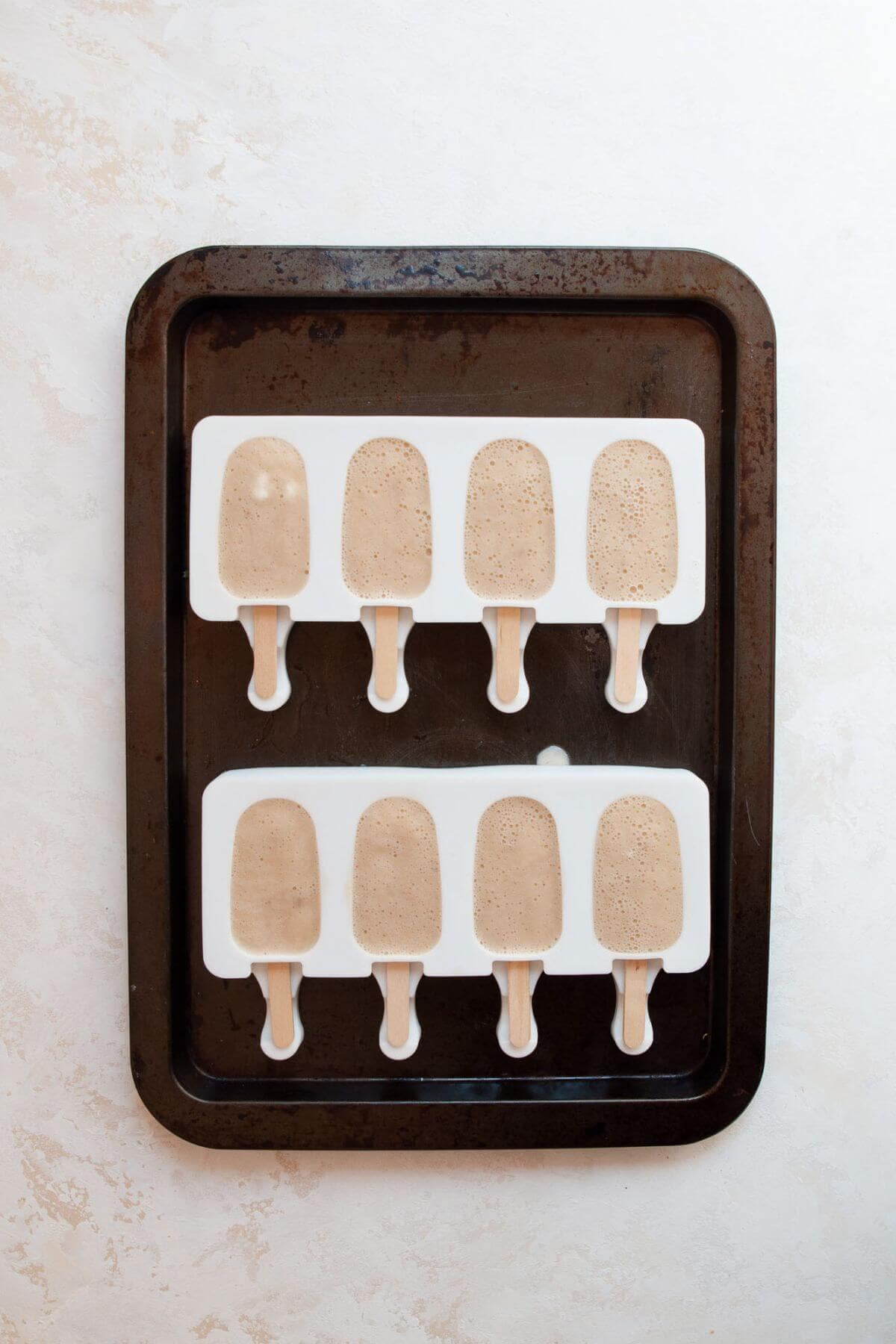 Frozen banana popsicles still in the molds, ready to enjoy.