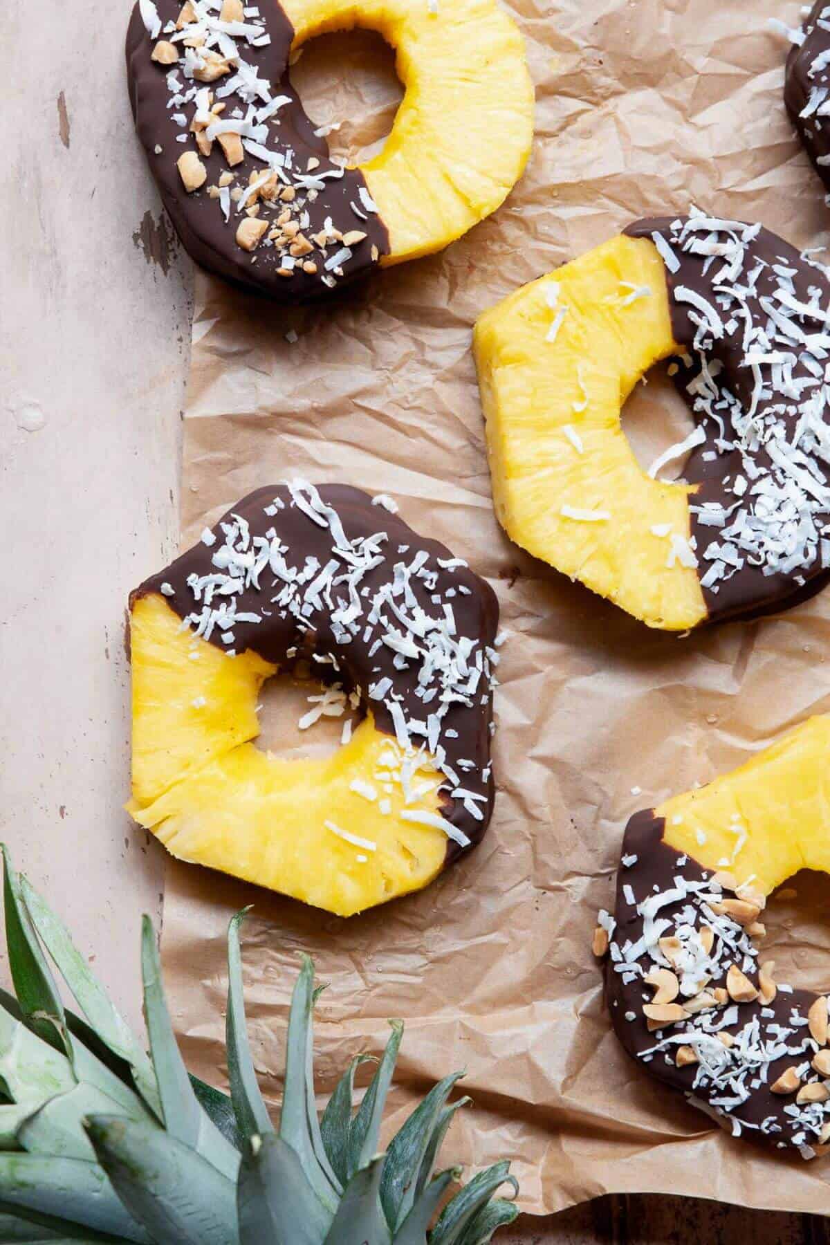 Healthy, 3 ingredient chocolate covered pineapple rings with crushed peanuts and coconut flakes.