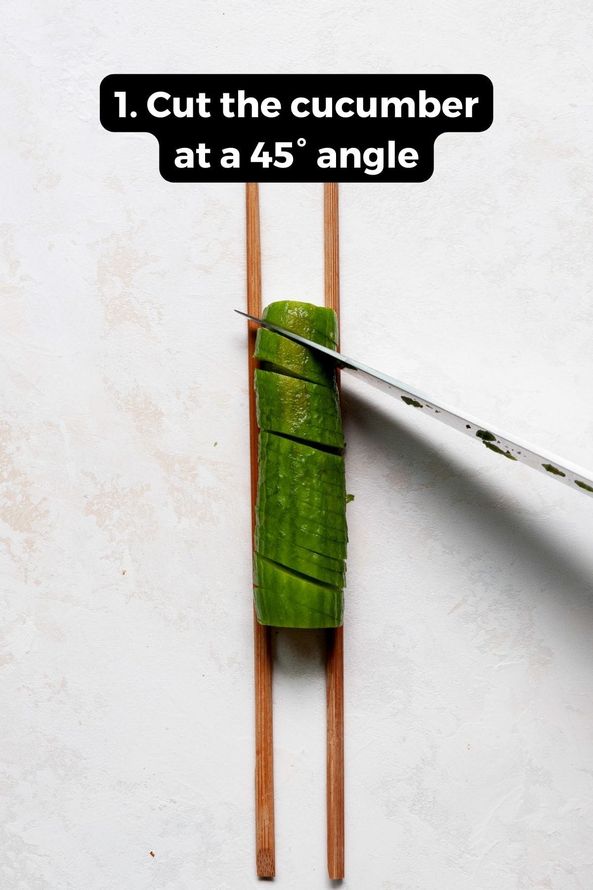 how to cut a mini cucumber at a 45-degree angle between two chopsticks
