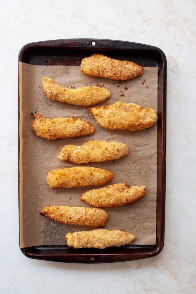 crispy cooked chicken tenders on a baking sheet