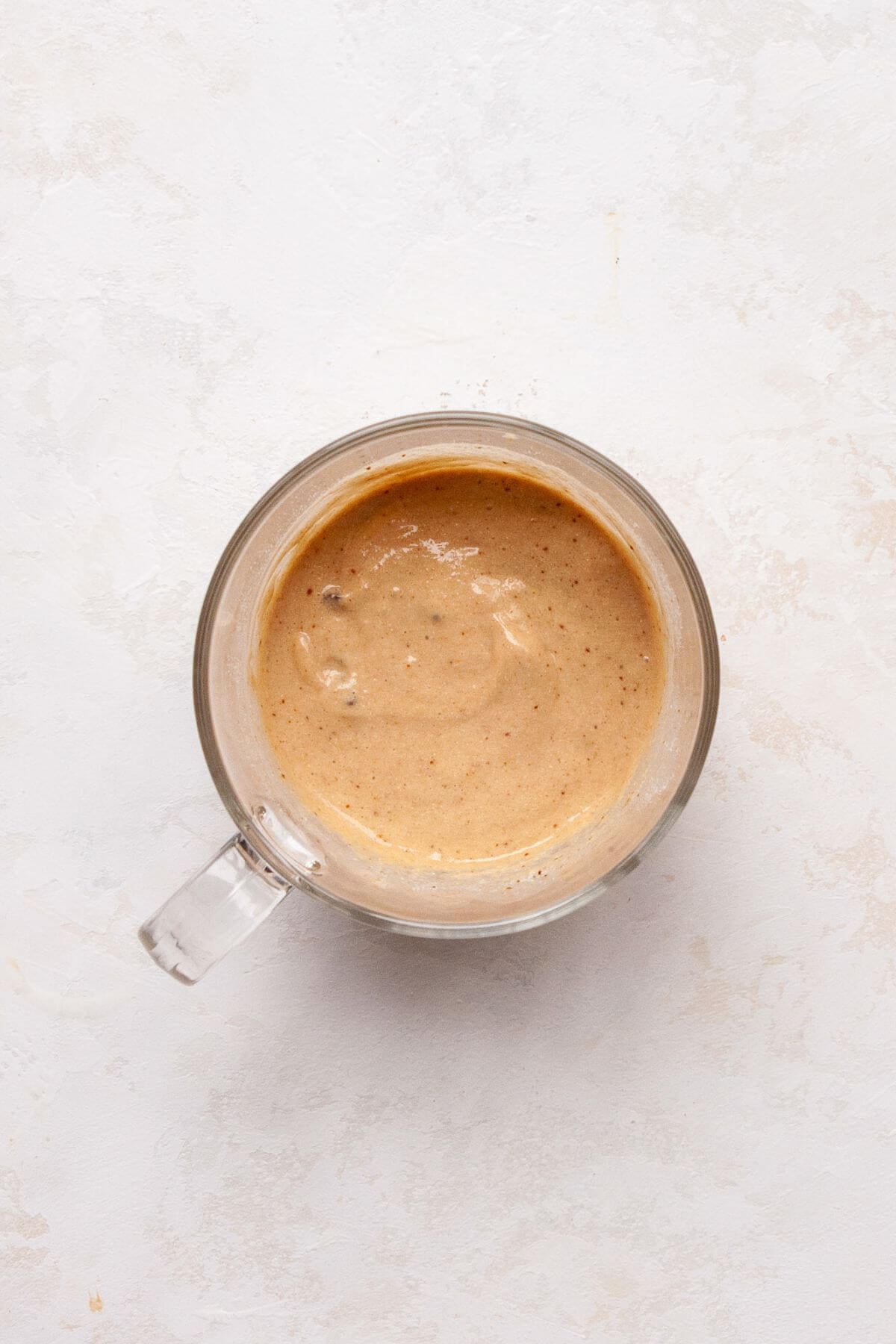 Protein mug cake batter in a glass mug before microwaving.