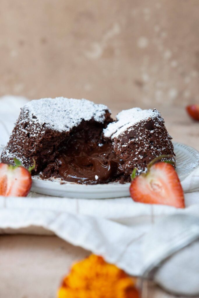 vegan lava cake cut in half with a gooey chocolate middle