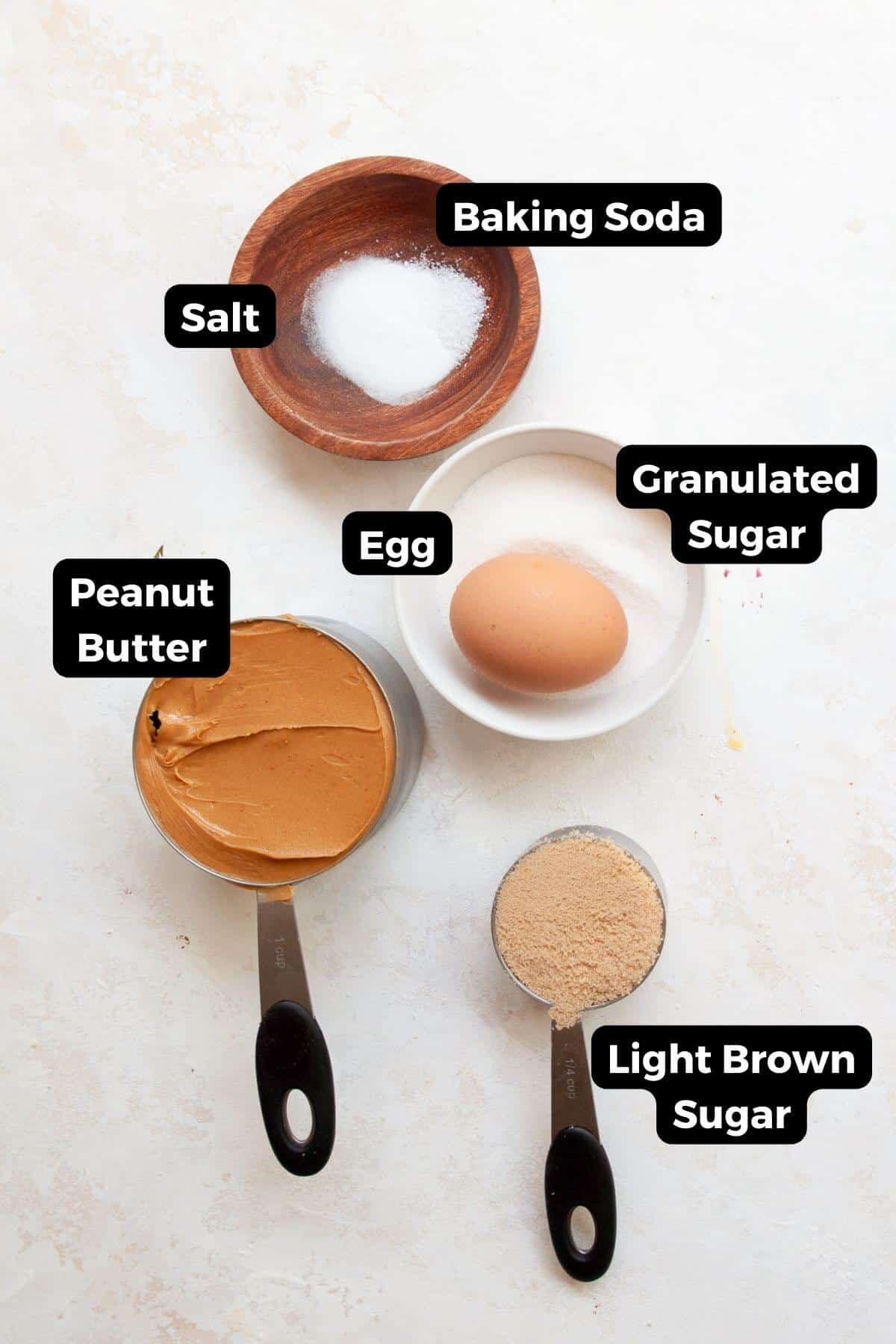 Ingredients for air fryer peanut butter cookies including peanut butter, brown sugar, granulated sugar, egg, baking soda, and salt.