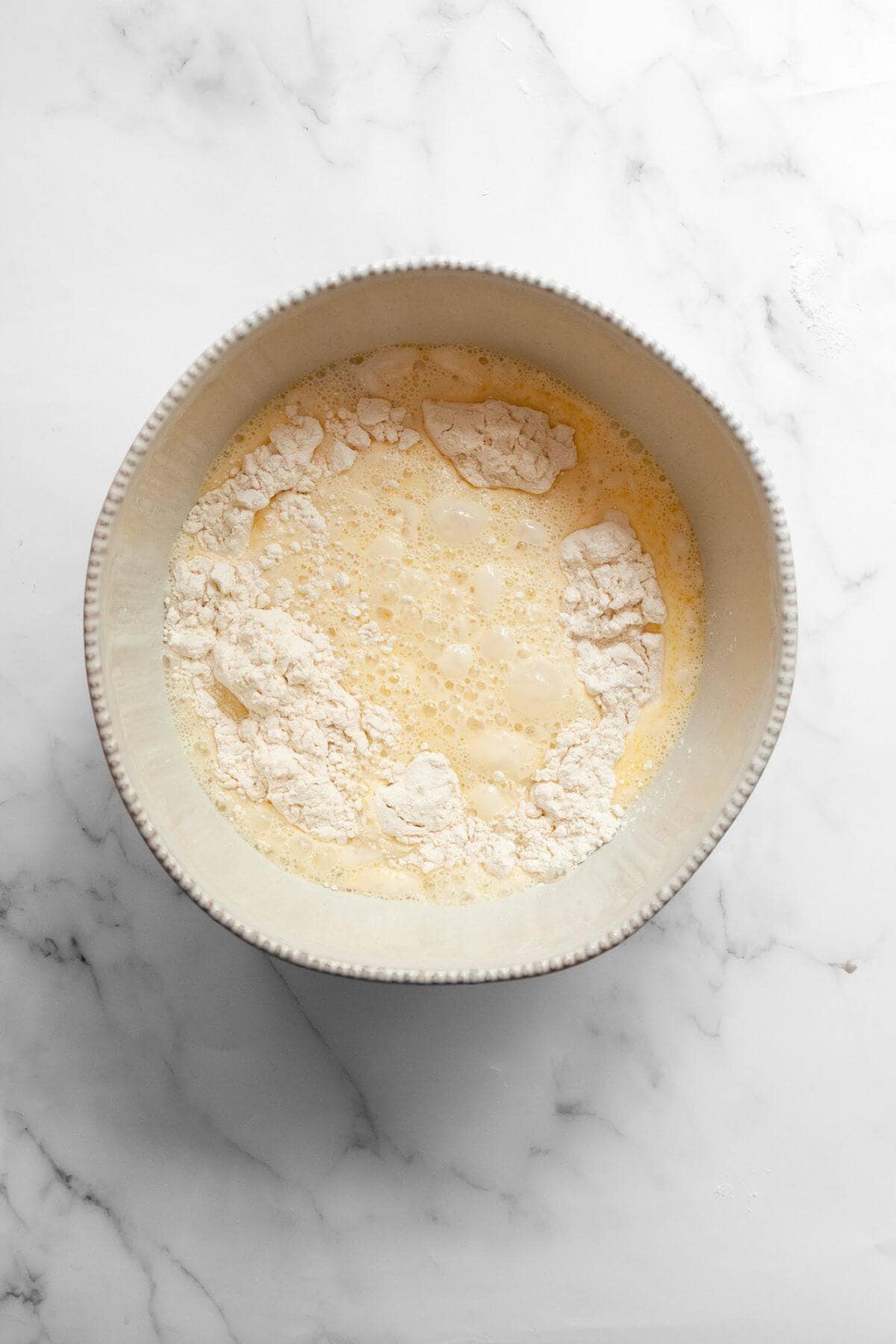 Dry and wet ingredients in a bowl before mixing dairy-free waffle batter.