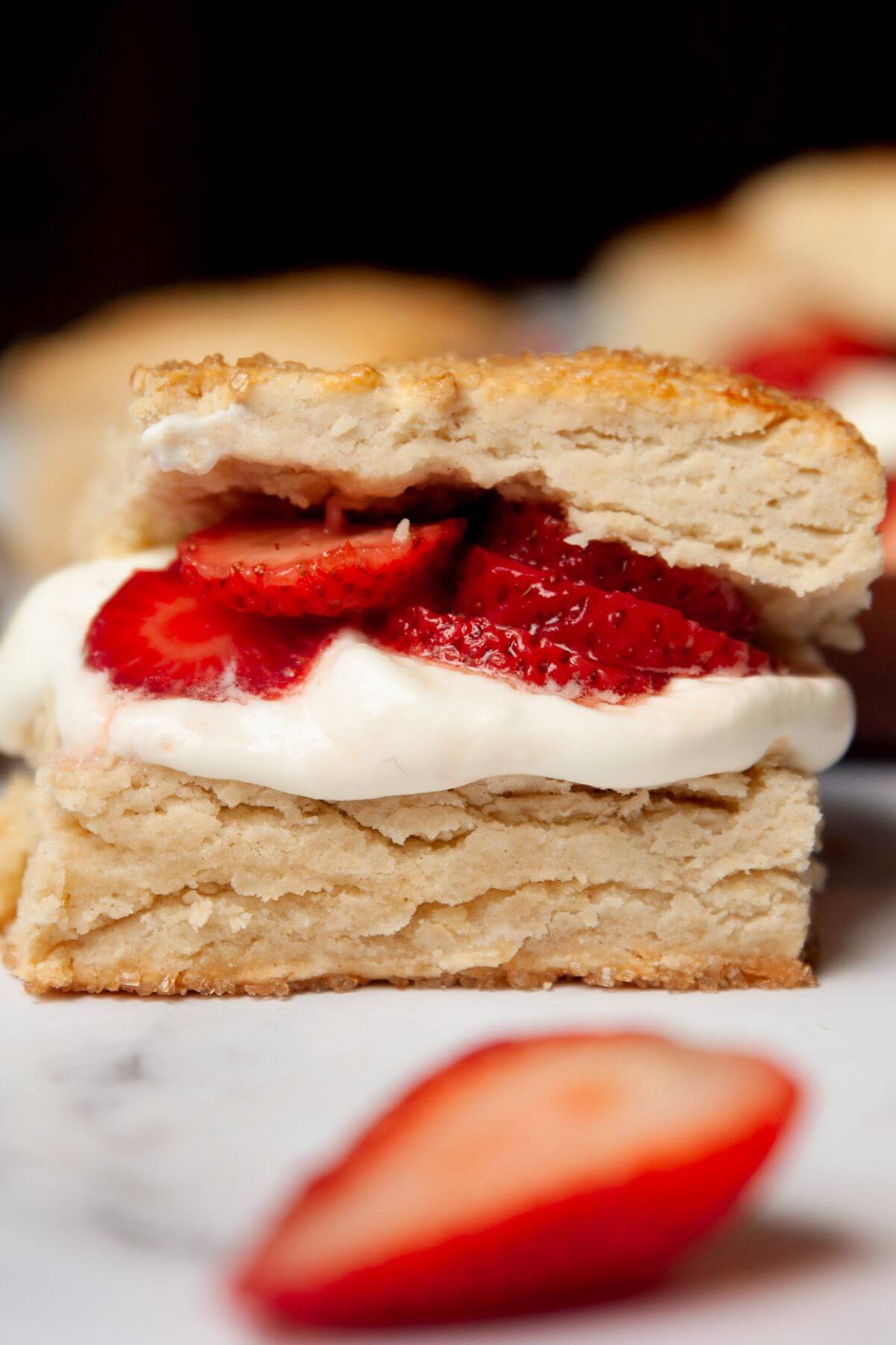 Gluten-free strawberry shortcake with flakey biscuits filled with whipped cream and strawberries.