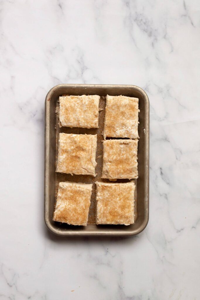 gluten-free buttermilk biscuit dough topped with course sugar unbaked on a baking tray