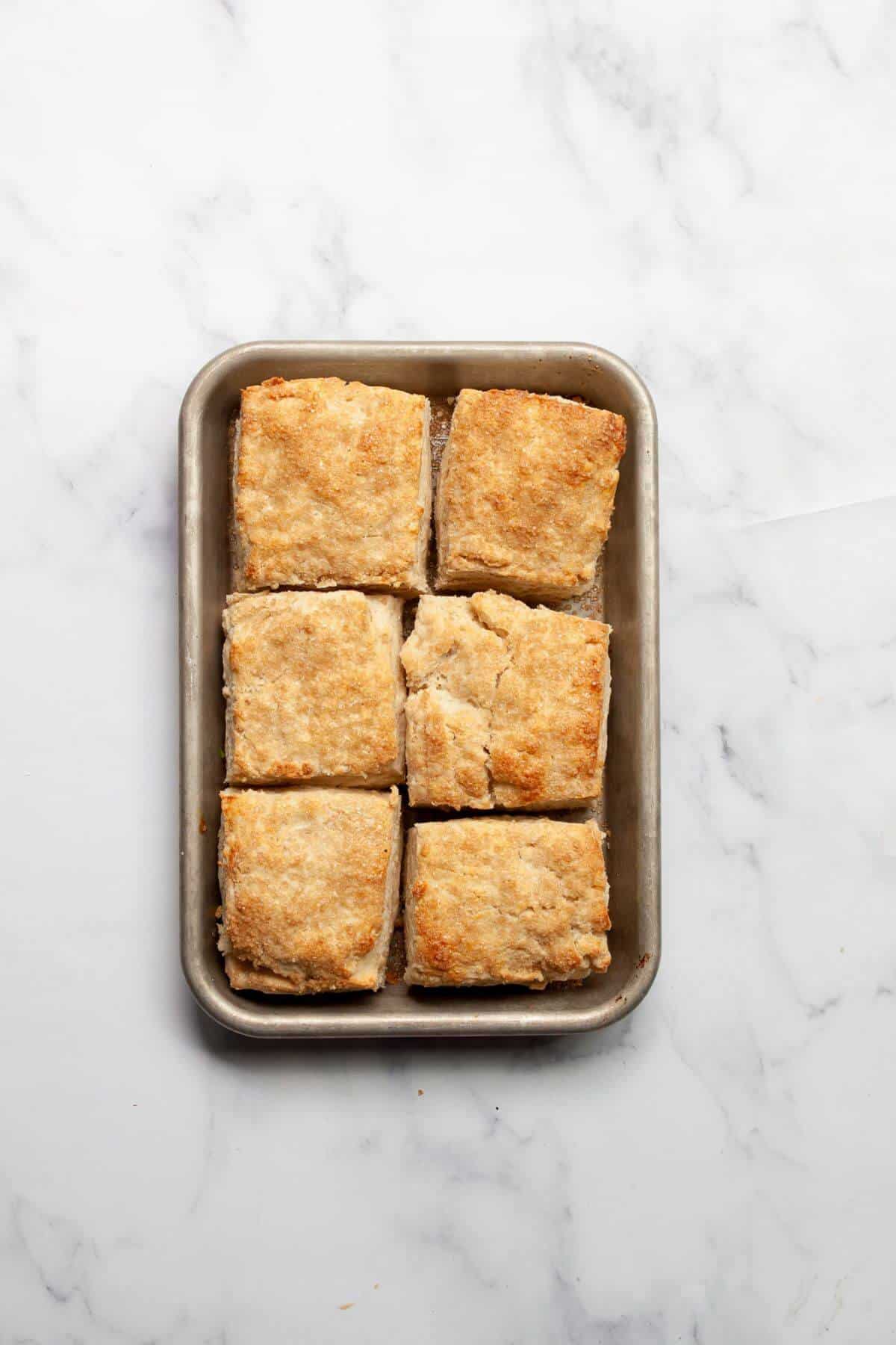Baked flakey gluten-free buttermilk biscuits on a tray.