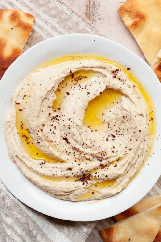 hummus in a bowl with olive oil and paprika on top