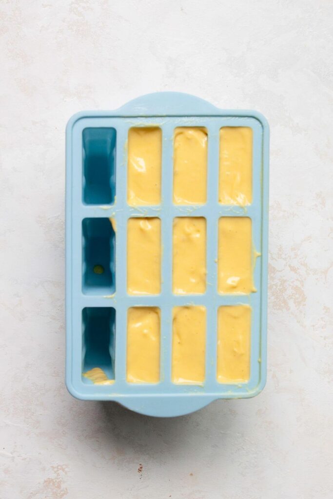 unfrozen mango popsicles in a mold