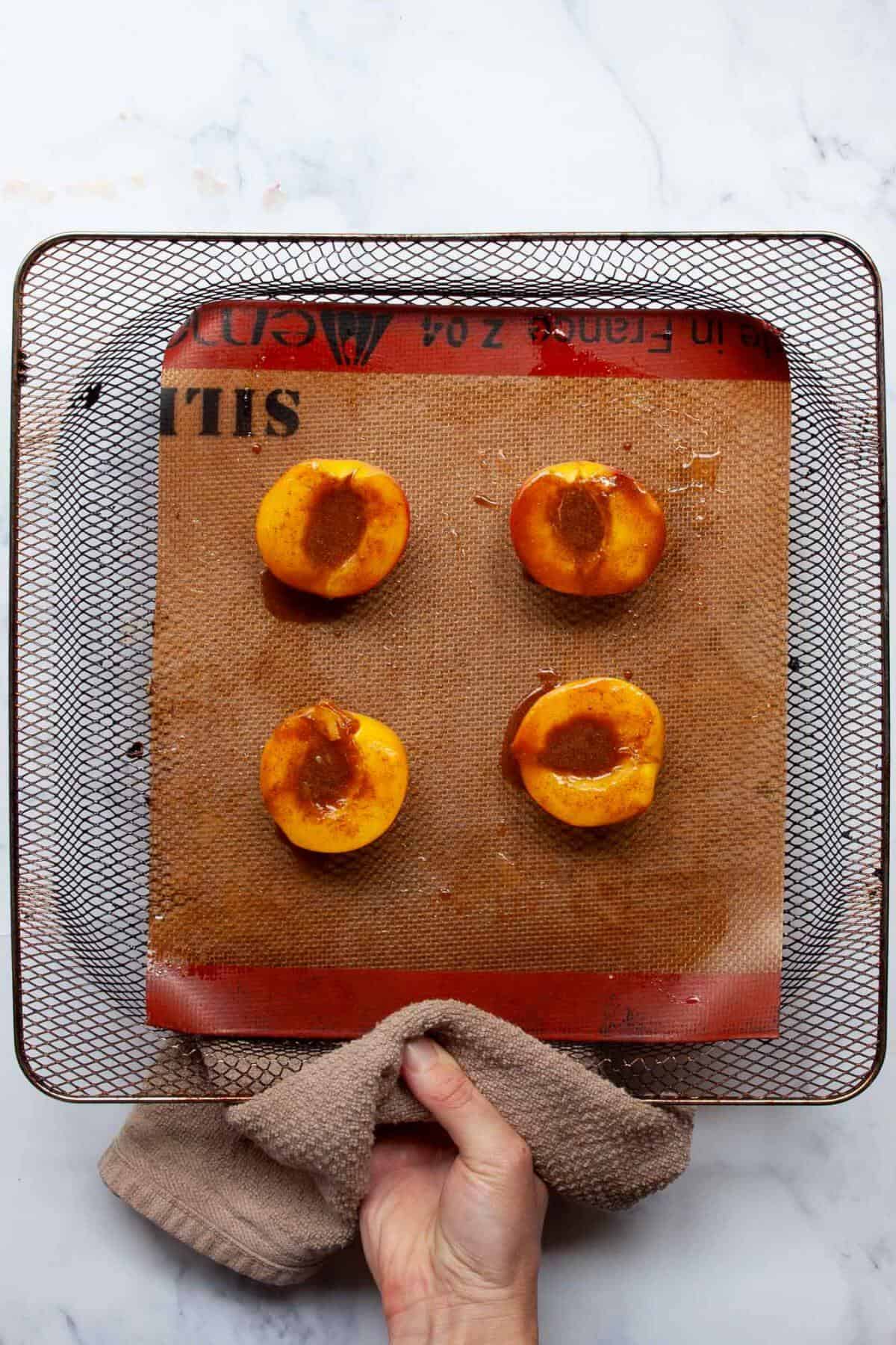 Flipping peach halves half way though air frying and brushing cinnamon maple syrup on top