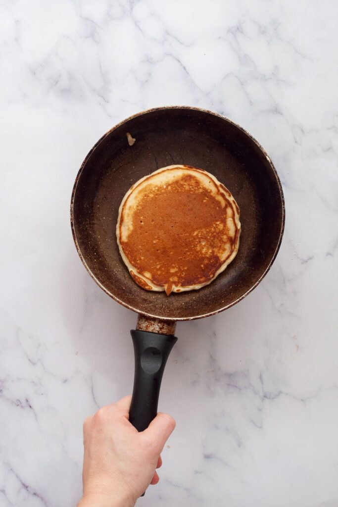 pancake in a cooking pan with buttery crispy edges