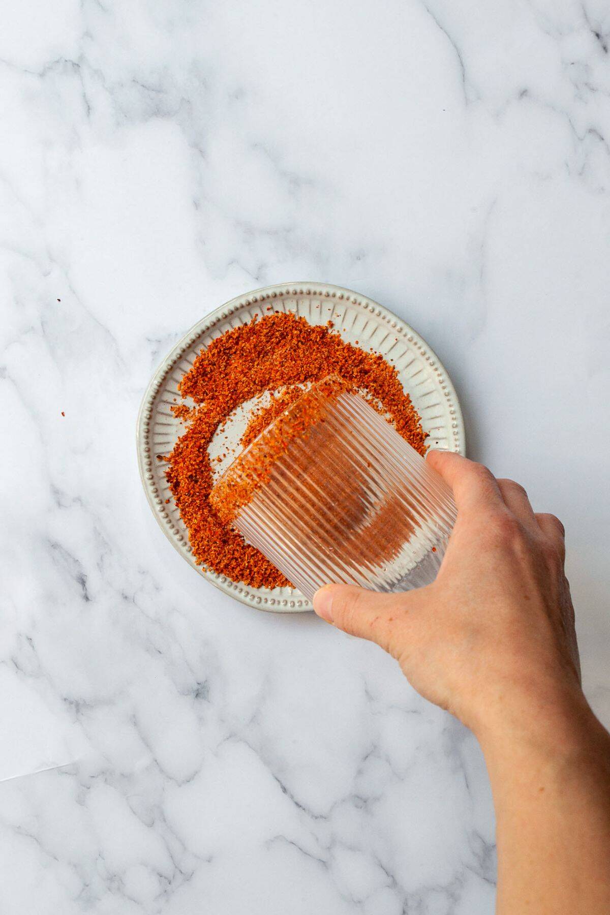 Adding a Tajin rim to a cocktail glass.
