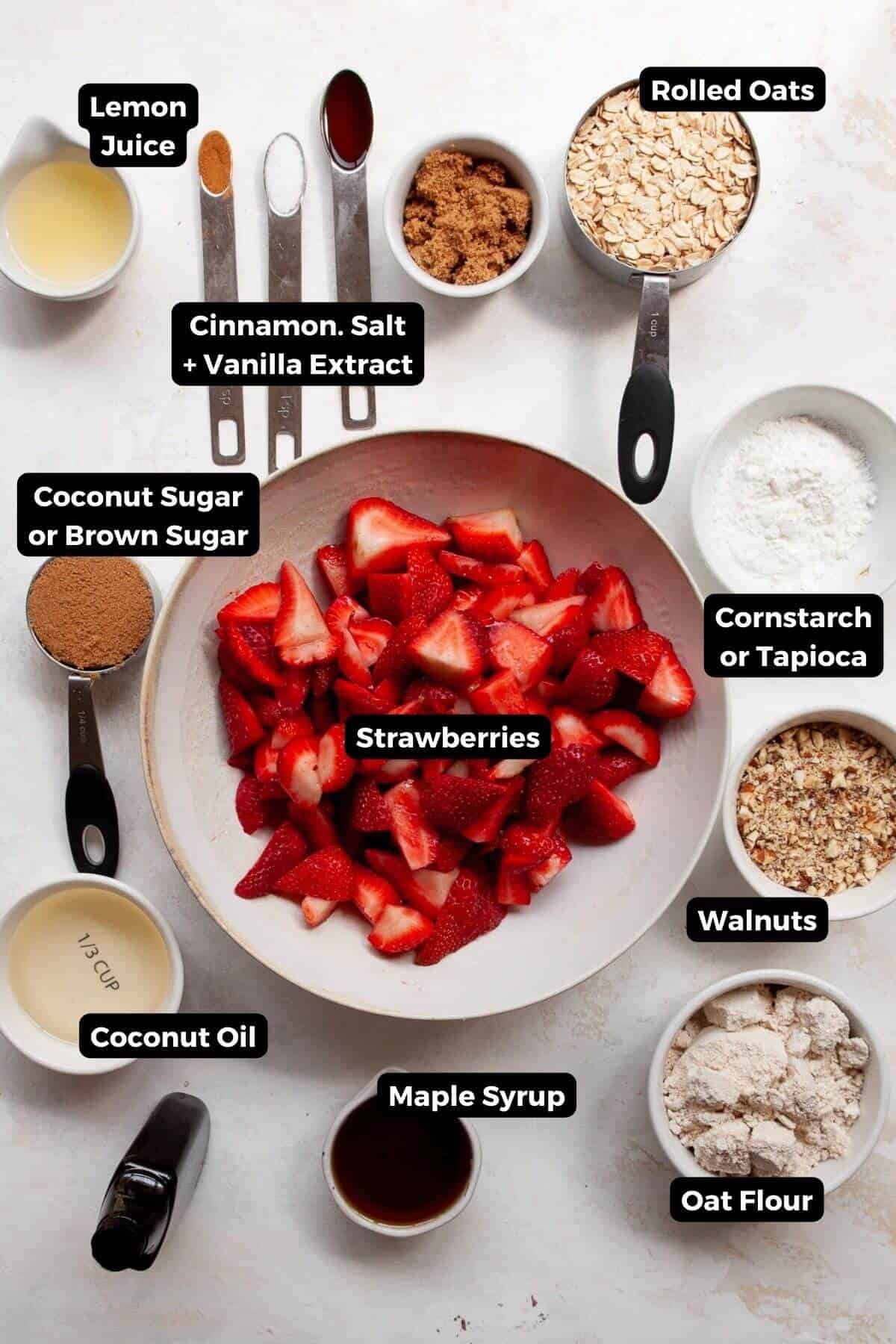 Strawberry crumble ingredients including fresh strawberries, rolled oats, oat flour, coconut oil, maple syrup, coconut sugar, and walnuts.