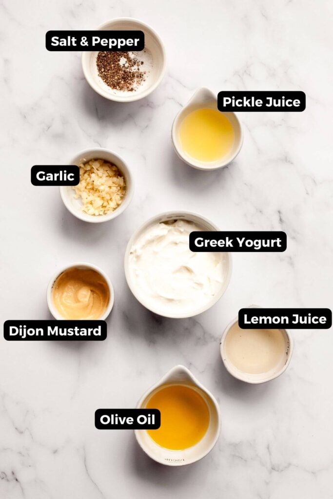 all ingredients in healthy greek yogurt caesar dressing in small bowls with labels