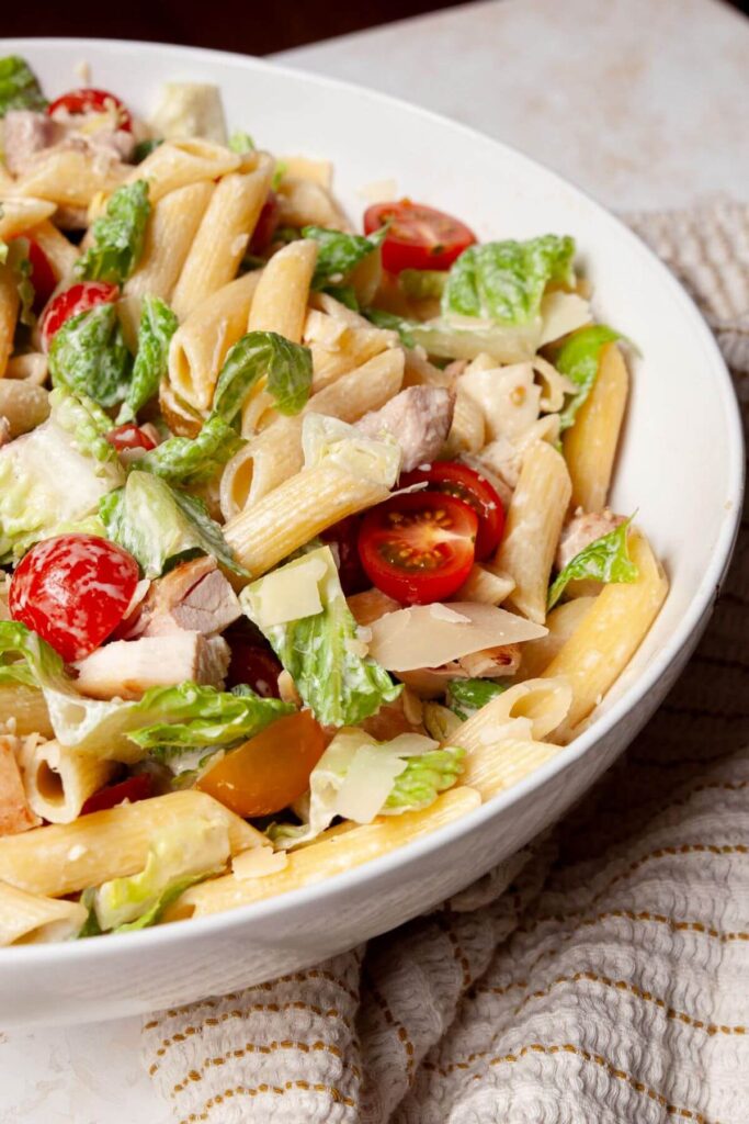 chicken Caesar pasta salad with penne pasta, tomatoes, and romaine hearts