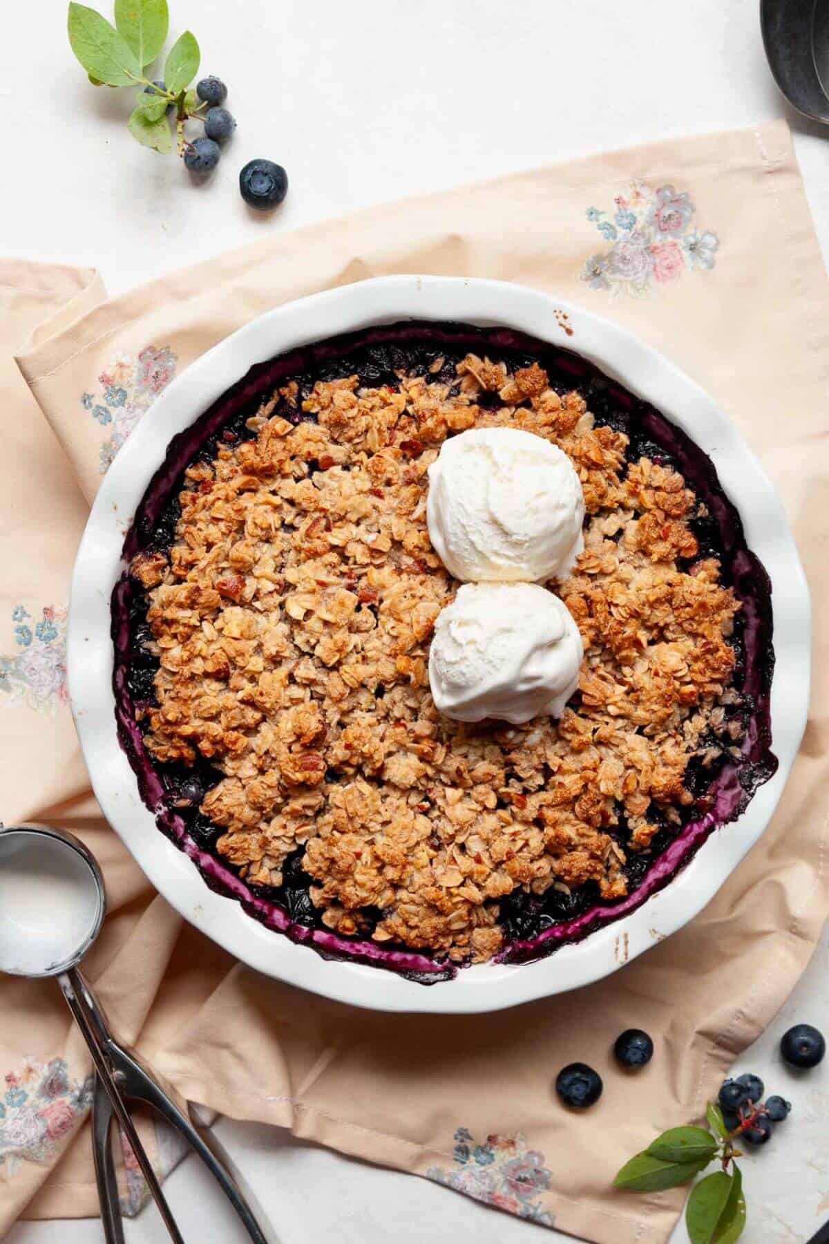 Healthy gluten-free blueberry crisp served with vanilla ice cream.