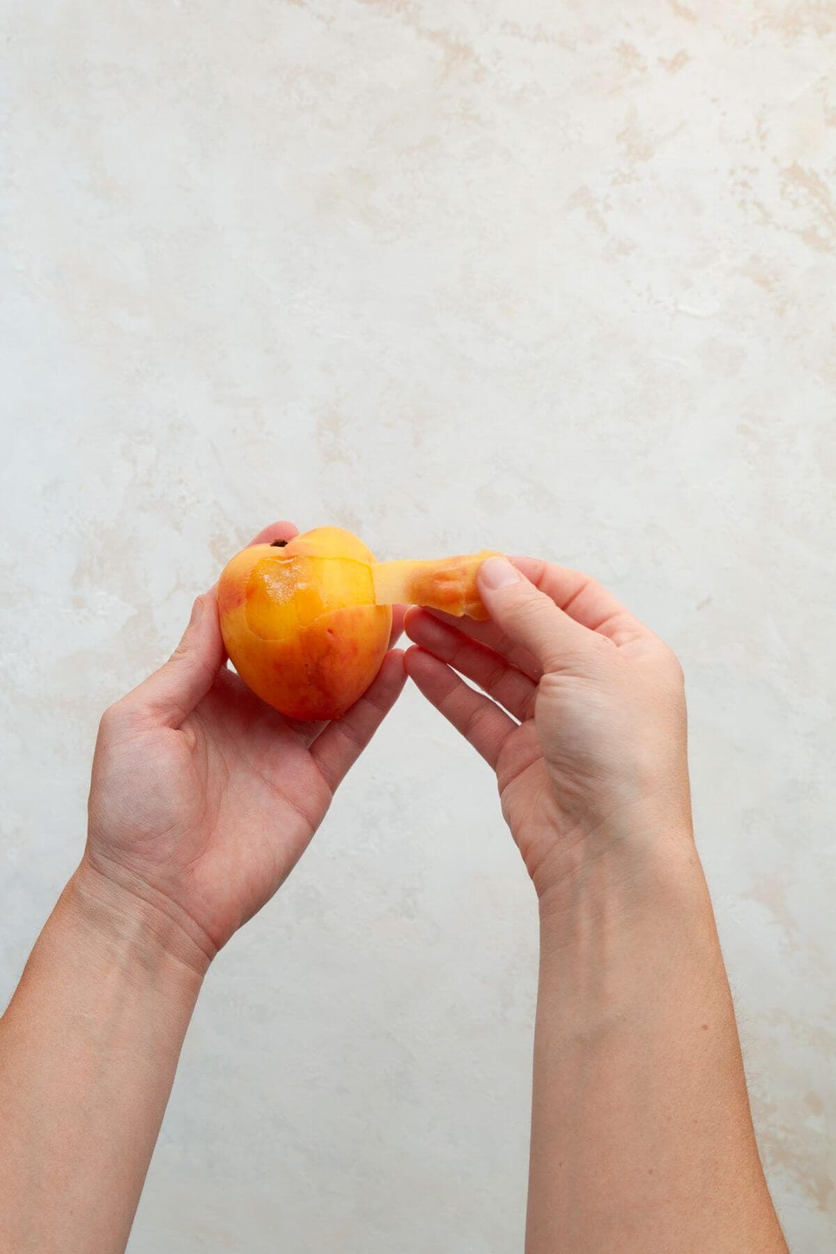 Peeling skin off peaches before cutting them.