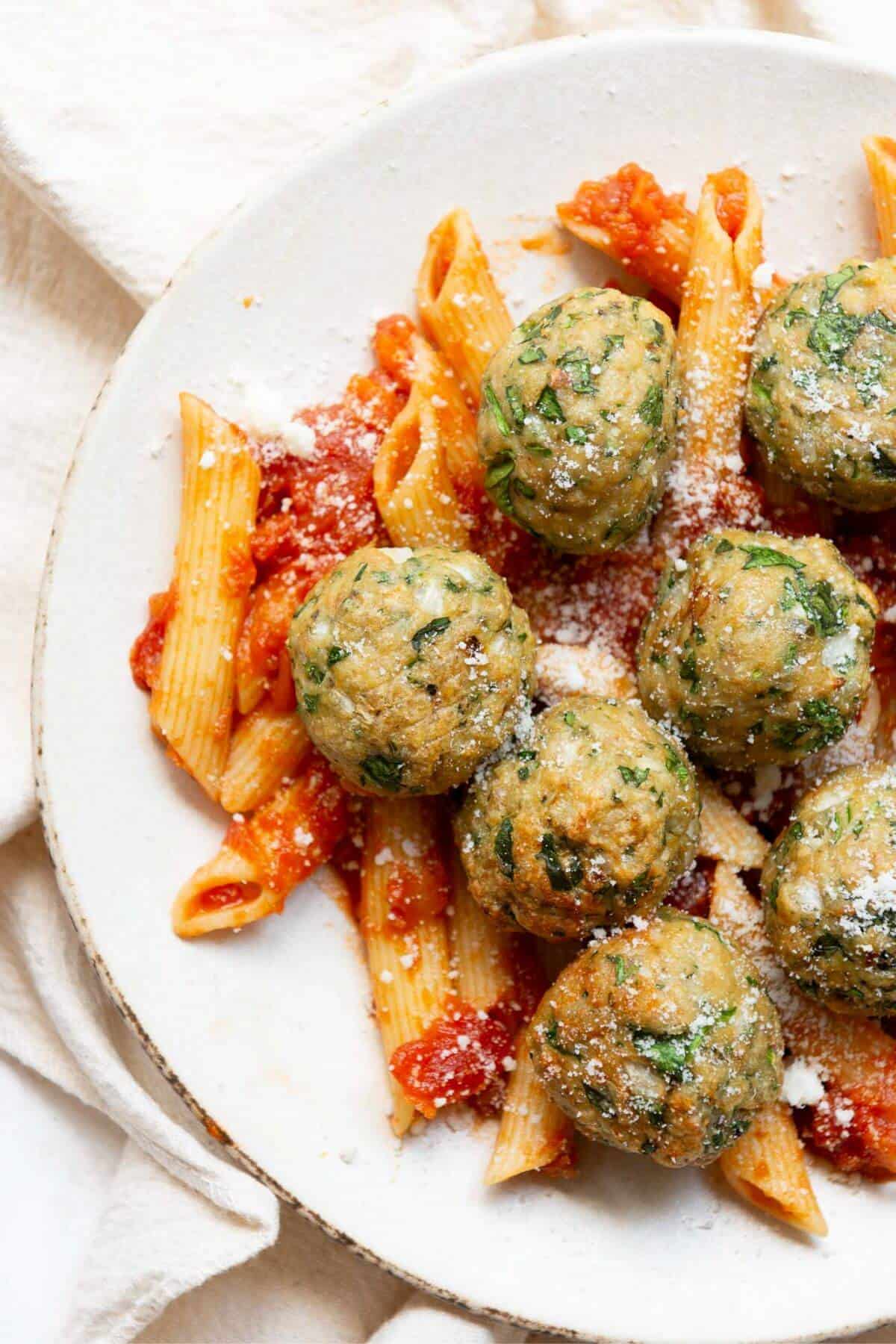 Juicy and crispy air fryer chicken meatballs with pasta, parmesan, and marinara sauce.