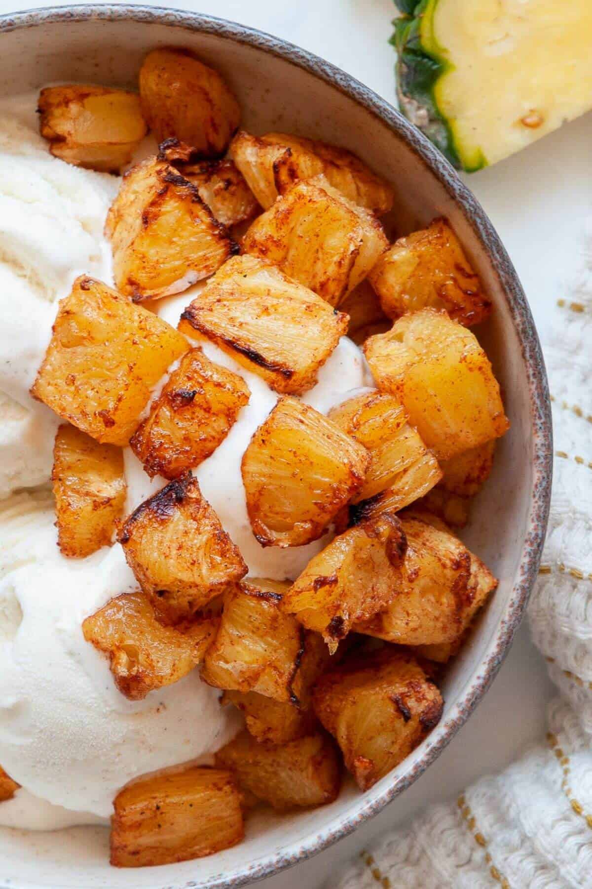 Close up of air fryer pineapple with caramelized edges in a bowl.