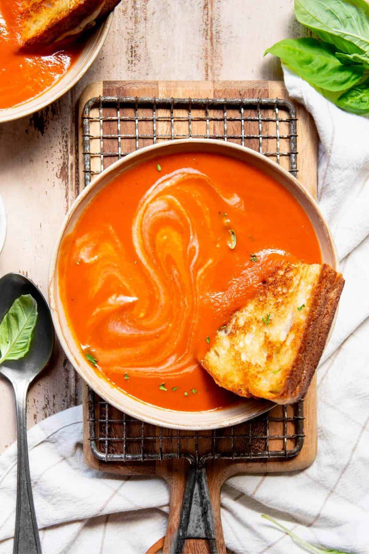 dairy-free tomato soup in a bowl with grilled cheese sandwich
