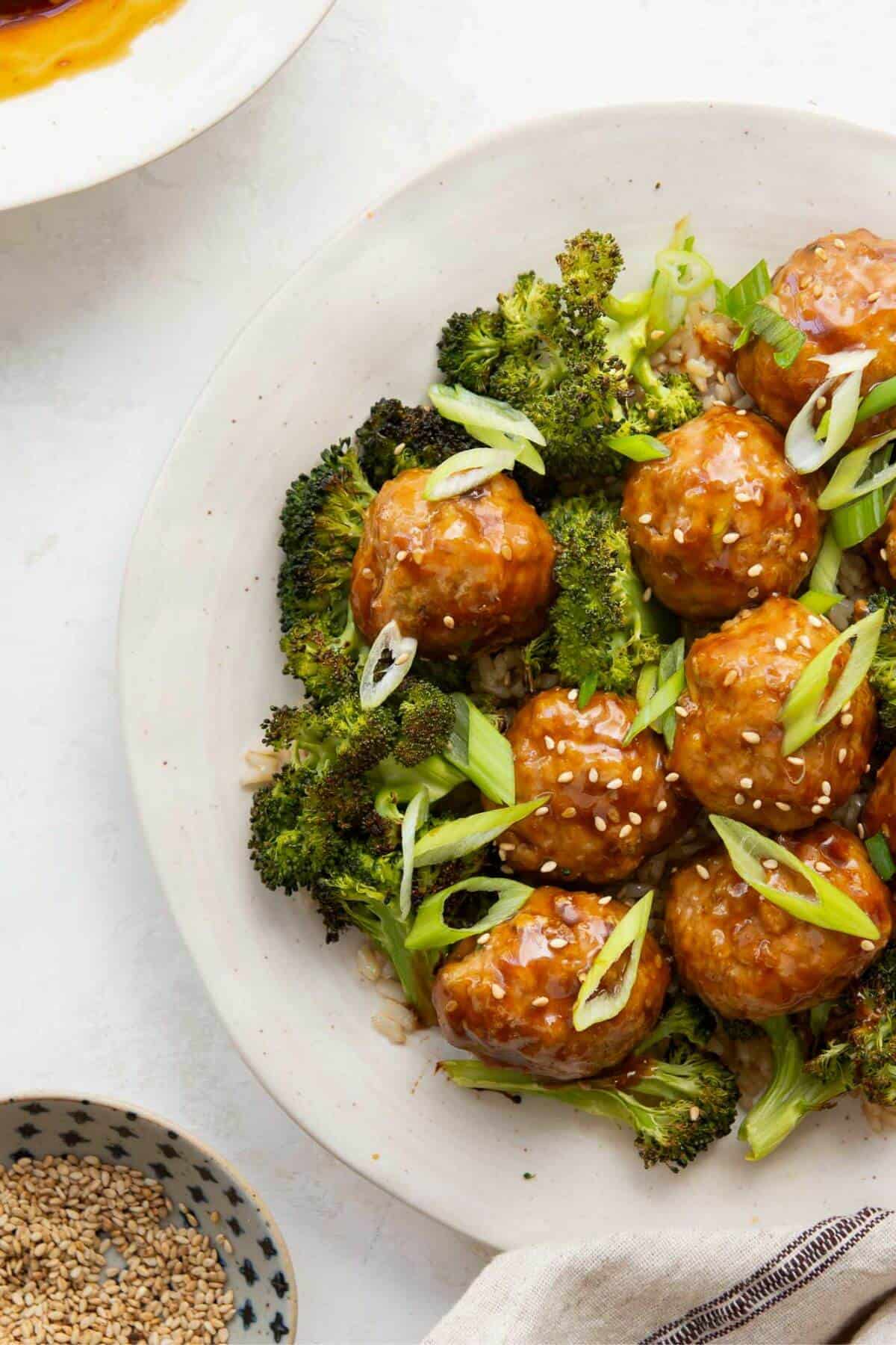 Teriyaki turkey meatballs on a plate with crispy broccoli and brown rice.