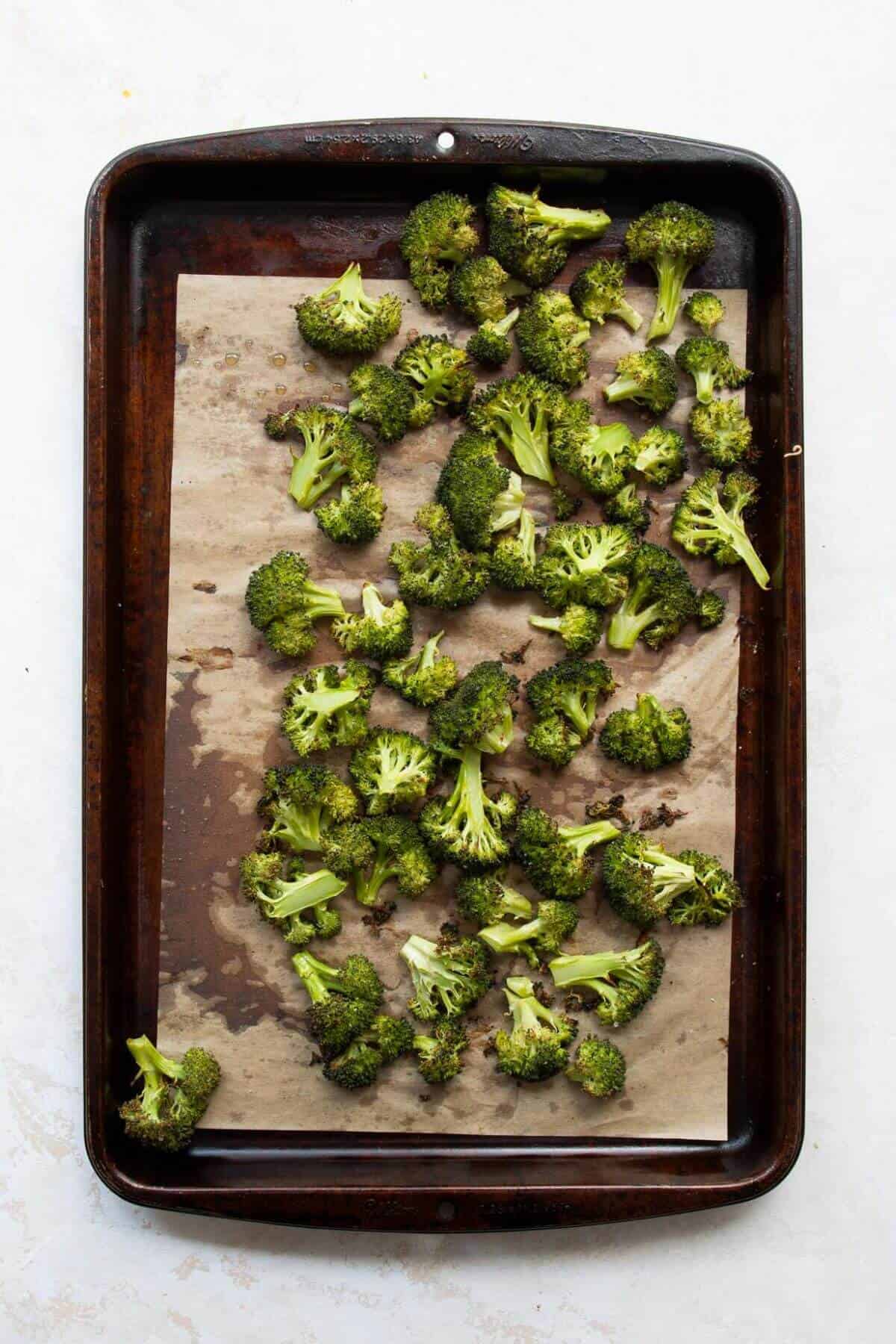 Crispy broccoli on a baking sheet after roasting.