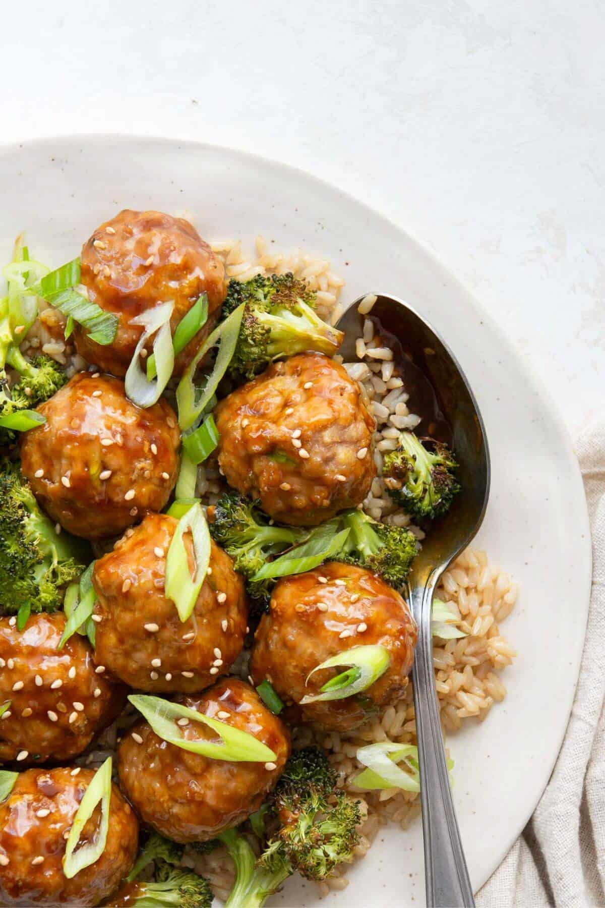 Sticky teriyaki turkey meatballs garnished with scallions and sesame seeds.