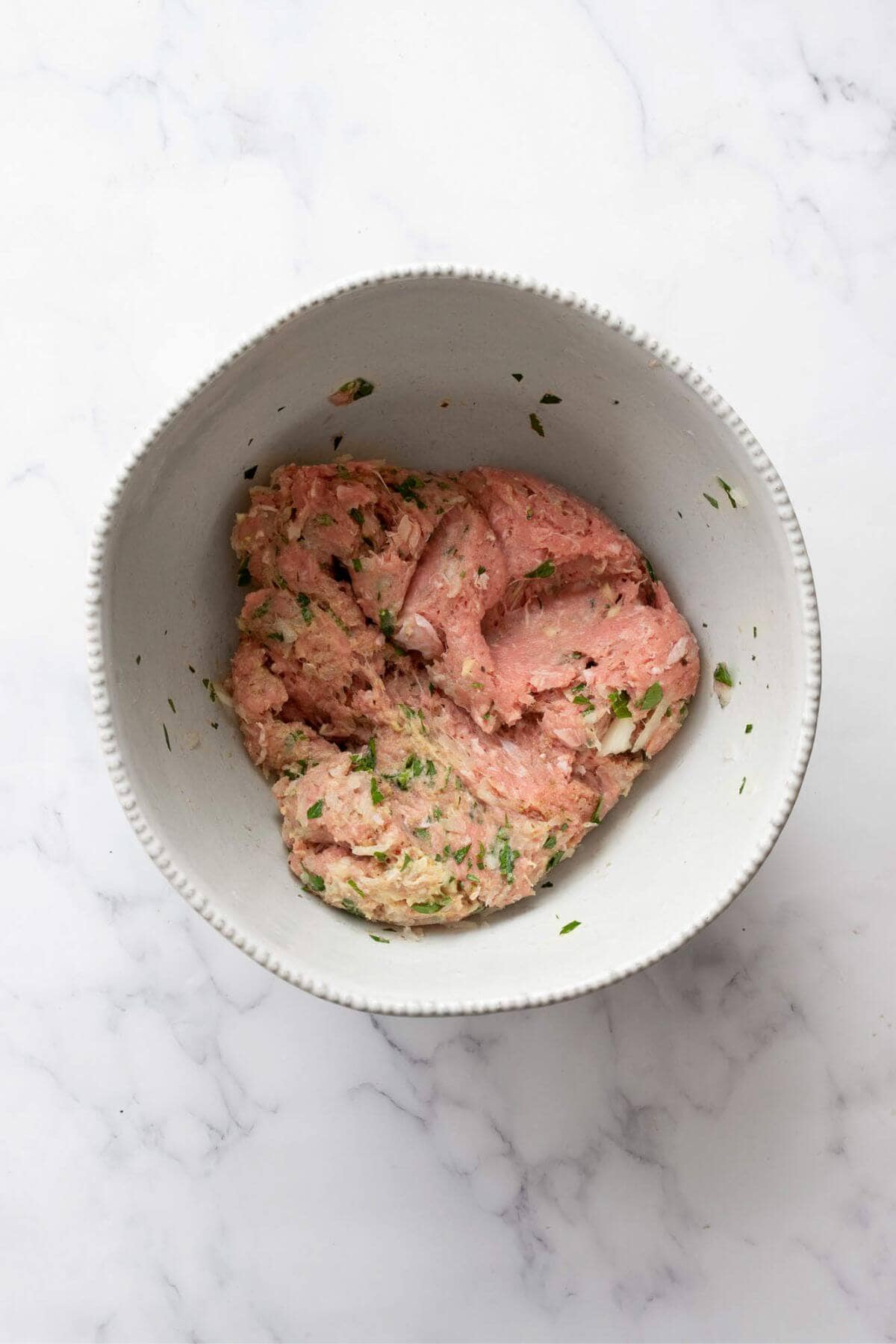 Ground turkey burger mixture in a bowl.