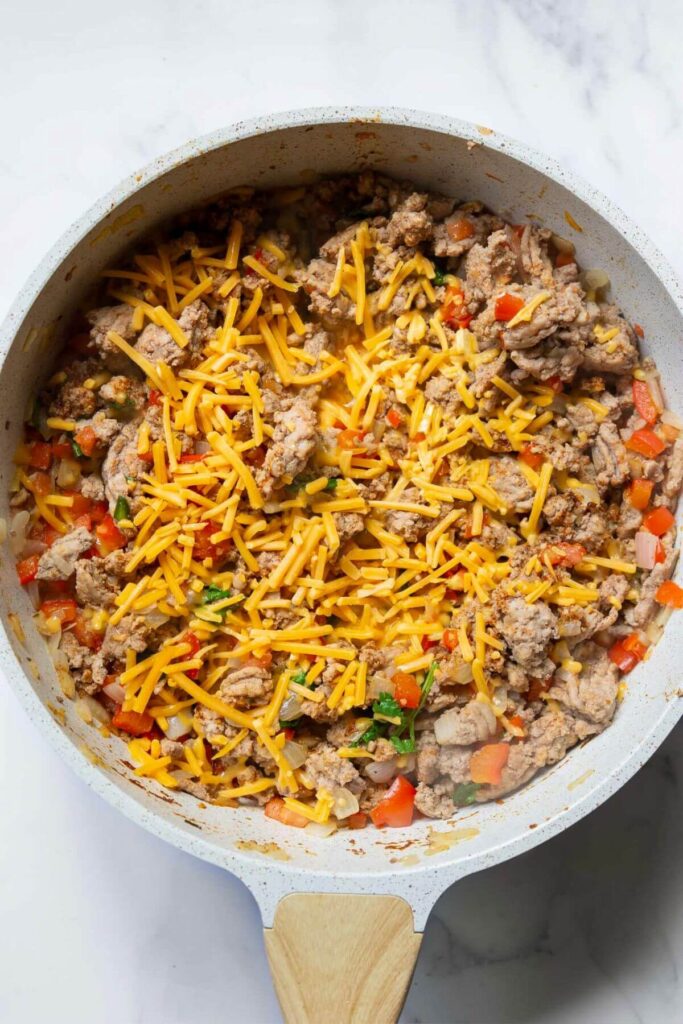 ground turkey taco filling with cheese on top in a skillet