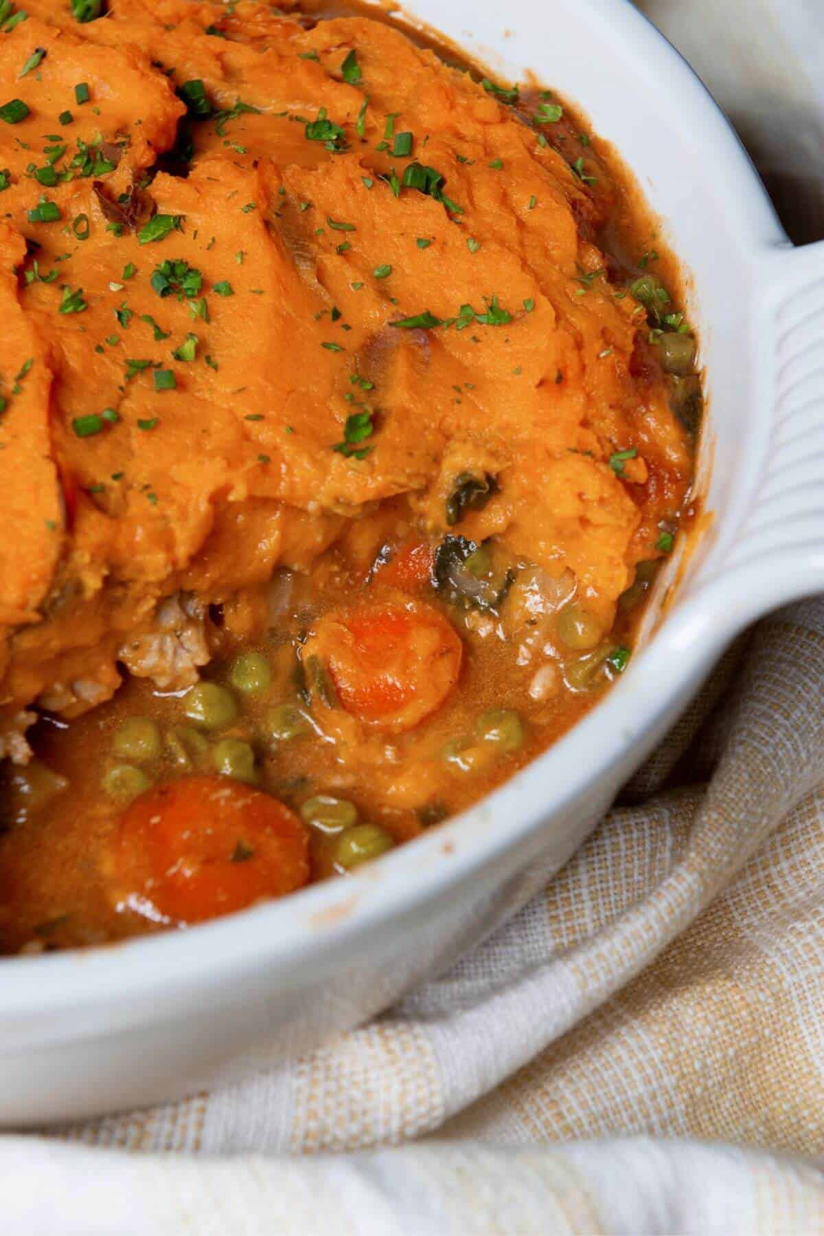 Healthy sweet potato shepherd's pie with savory, saucy ground chicken and veggie filling.