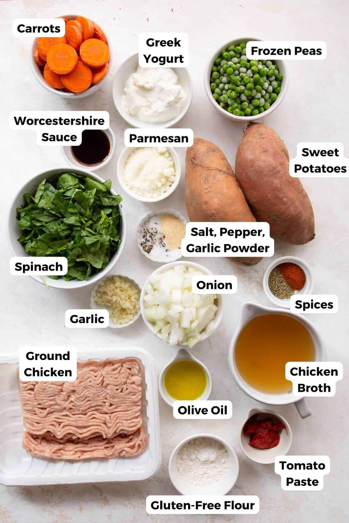 All ingredients in shepherd's pie in small bowl including sweet potatoes, ground chicken, peas, chicken broth, onion, seasonings, garlic, olive oil, Worcestershire sauce, greek yogurt, and parmesan.