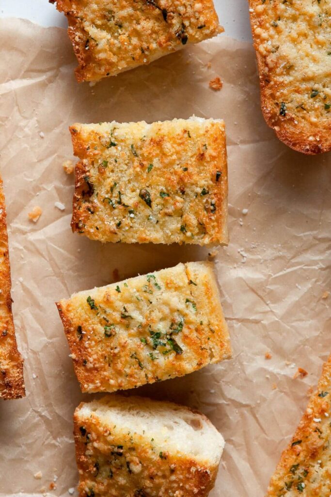 close up of air fryer garlic bread slices with parmesan and parsley