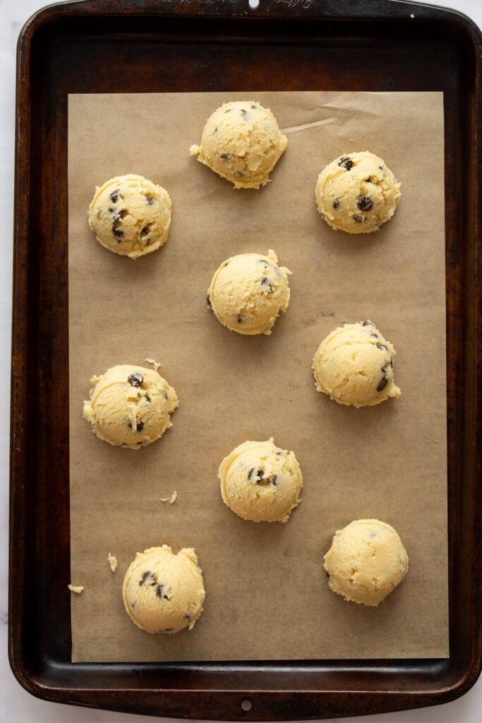 cookie dough balls scooped onto baking sheet before shaping and smoothing out