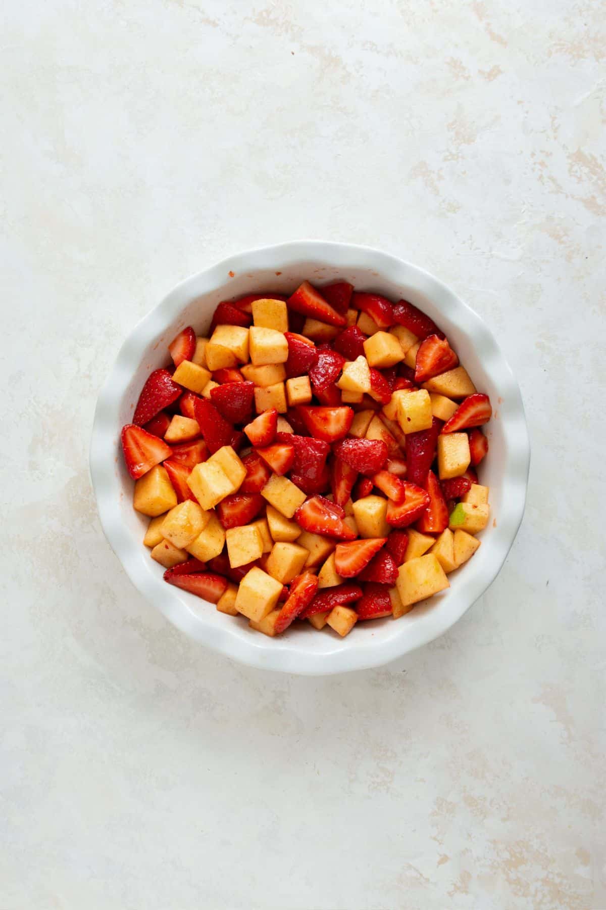 Strawberry and apple filling in a pie dish.